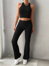 a woman doing yoga while wearing a black savvy innovation chic ribbed knit pants set 