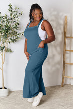 Side angle of Cyrella Muse dungarees in French Blue, highlighting wide-leg cut.