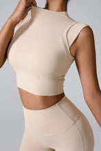 a model posing in the tan mock neck active tank top