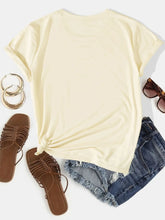 Back view of CaliVista Round Neck Tee in tan, laid flat to show shoulder seams and clean stitching, paired with distressed jean shorts, brown sandals, ear rings, and sun glasses.