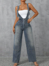 Model styled in Denivelle™ Light Blue Denim Overalls with heels and statement jewelry.