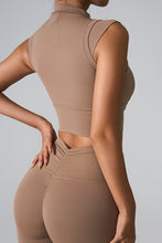 a woman modeling the back view of the Camel color mock neck active tank