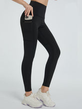 side view showing stretch fabric of virexaform sculpt leggings black with phone in side pocket