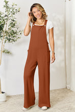  Ochre Cyrella Muse Overalls styled with a white tank and open-toe heels.