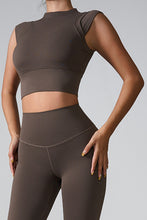 a model posing the front view of the Mocha color Mock Neck Active Tank