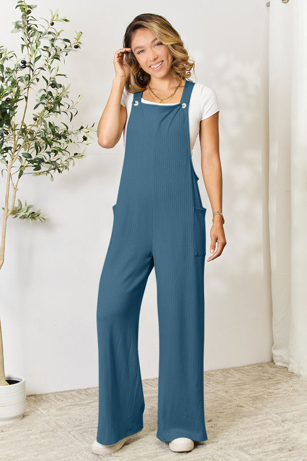 Model in Cyrella Muse Wide-Leg Overalls in French Blue, front view with hands in pockets.
