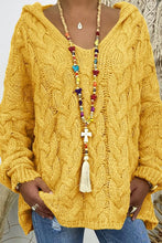 Close-up photo of model wearing the Banana Yellow color Tessyra Cable-Knit Hooded Sweater paired with jewelry and blue denim jeans.