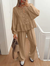 Model walking through condo hall in BellaraNova camel set with sneakers and camel shoulder bag