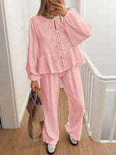 Model walking through condo hall in BellaraNova dusty pink set with sneakers and camel shoulder bag