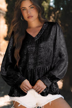 Model wearing Glimmerelle™ Blouse in Black, paired with distressed jeans and sneakers at the city movie theater.