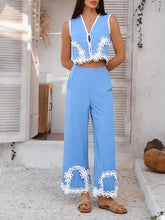 Woman in blue Xyvello Set posing by cottage door highlighting intricate contrast design on premium fabric