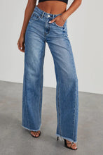 Model styling BluviaFold™ raw hem jeans with blouse and heels