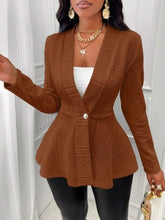 A woman wearing the brown One Button Textured Peplum Cardigan paired with a white top, black pants, jewelry, and heels at an art gallery in San Francisco.