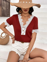 Lifestyle shot of model wearing a burgundy Lace Detail V-Neck Short Sleeve T-Shirt while enjoying a patio brunch, paired with high-rise jeans and sunglasses.
