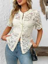 Model wearing the cream lace button-down shirt at an outdoor café, paired with a straw bag and tan sandals for a chic, effortless brunch look.