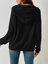 Back view of the Calvessa Hoodie in black, showcasing the relaxed drape and cozy, lightweight ribbed texture.