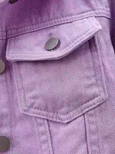 A close up photo of the button detail, pocket, and quality fabric of a lavender Full Size Cropped Denim Plus Size Jacket.