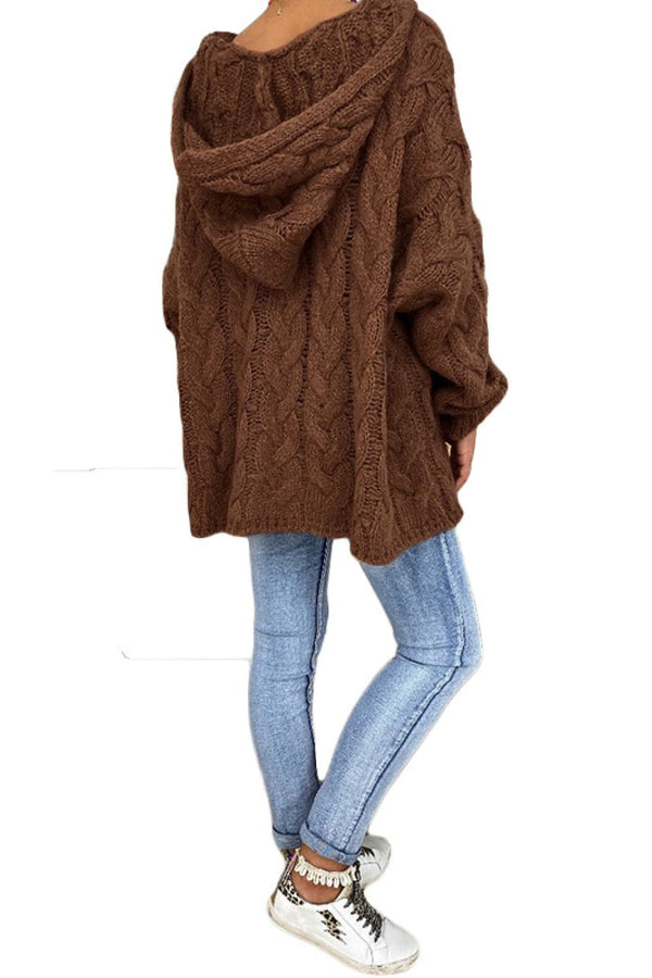 Model showcasing the back of a chestnut color Skyloft Cable-Knit Hooded Sweater paired with jewelry, blue denim jeans, and white sneakers.