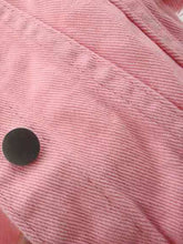 A close up photo of the button detail and premium fabric of the Pink Full Size Cropped Denim Plus Size Jacket.