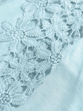 Close-up of the lace floral detailing on the shoulder cutouts.