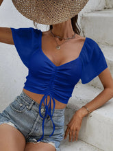 Close-up of adjustable front-center drawstring on Glowflutter Crop Top in royal blue, highlighting stretch fabric and ruching.