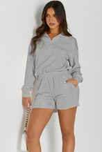 a woman wearing a cloudy blue Half-Button Sweatshirt and Shorts Active Set