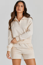 Woman wearing a cream Half-Button Sweatshirt and Shorts Active Set.