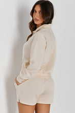 Woman in a cream Half-Button Sweatshirt and Shorts Active Set rear view.