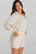 Woman wearing a cream Half-Button Sweatshirt and Shorts Active Set.