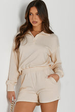 Woman in a cream Half-Button Sweatshirt and Shorts Active Set posing for a picture.