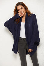 Woman attending an evening art gallery event in Dark Navy SeraphinaWing Cardigan, styled with wide-leg trousers and heels.