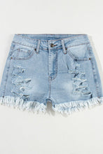 4Flat lay of light blue distressed high waist denim shorts, front view showing button closure, frayed hem, and distressed details.