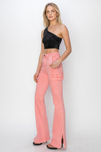 Full model shot of flamingo  RISEN cargo bootcut jeans showing slit and leg shape styled with velvet assemmetrical crop top.