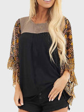Model wearing BlossomEase Blouse in black with floral sleeves and relaxed fit.