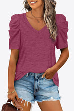 Model wearing a bold fuchsia V-neck puff sleeve tee, adding a pop of color to a neutral bottom outfit.