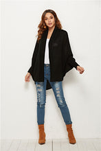 Woman heading to an evening rooftop gathering in Black SeraphinaWing Cardigan, paired with skinny jeans and ankle boots.