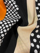 Flat lay close-up of romper's textured earth-tone color block fabric, highlighting the high-quality polyester-elastane blend and artistic geometric contrast.