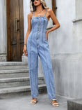 Model wearing Gildoria™ Spaghetti Strap Denim Overalls in light blue, front view showcasing exposed seams and half-button-up detail.