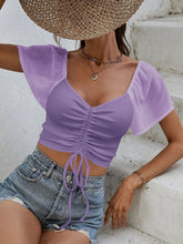 Model in pink purple Glowflutter Crop Top paired with gold necklace and blazer, styled for casual-chic day look.