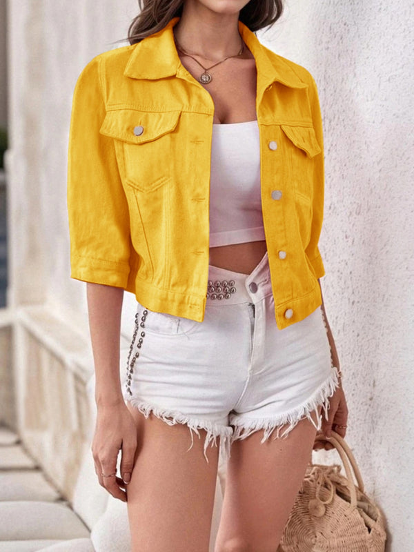 A woman wearing the Gold Full Size Cropped Denim Plus Size Jacket paired with white denim shorts, a white top, and a straw handbag at Sandals resort.