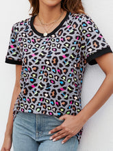 Front view of gray dawn leopard print short sleeve tee styled with black jeans and ankle boots for a casual-chic vibe.