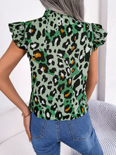 Back view of green leopard print blouse with cap sleeves and adjustable tie-neck ribbon gently falling at the back neckline.