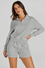 Model posing in cloudy blue Half-Button Sweatshirt and Shorts Active Set highlighting fabric quality, half button-up, and collar.