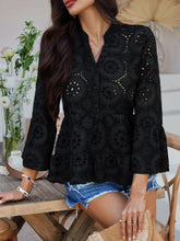 Side view of Luméa™ Blouse in Black, styled with a tan ruffled handbag and sneakers for a casual outing.