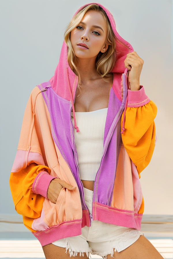Model wearing a heliotrope purple Full Size Color Block Zip Up Hoodie, featuring bold contrast panels, front zipper closure, and relaxed hooded fit.