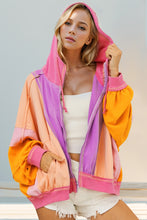 Model wearing a heliotrope purple Full Size Color Block Zip Up Hoodie, featuring bold contrast panels, front zipper closure, and relaxed hooded fit.