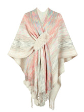 Front view of ivory Heathered Fringe Hem Poncho arranged flat, featuring airy heathered fabric, multicolor contrast detailing, and playful pom pom fringe.
