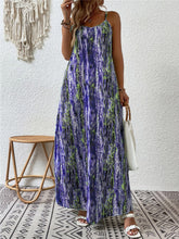 Woman at a rooftop party in the electric purple color Jewel of Northern Lights Maxi Cami Dress paired with jewelry, a white handbag with a wooden round strap, and white heels.