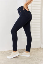 a woman modeling a side view of the Navy Judy Blue Full Size Garment Dyed Tummy Control Skinny Jeans at casual party