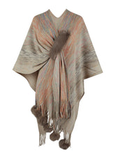Front view of khaki Heathered Fringe Hem Poncho, showing its soft heathered knit, multicolor thread details, and pom pom trim at the hemline.